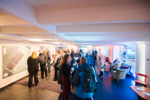 Mehrere kleine Personengruppen unterhalten sich in einem großen Raum